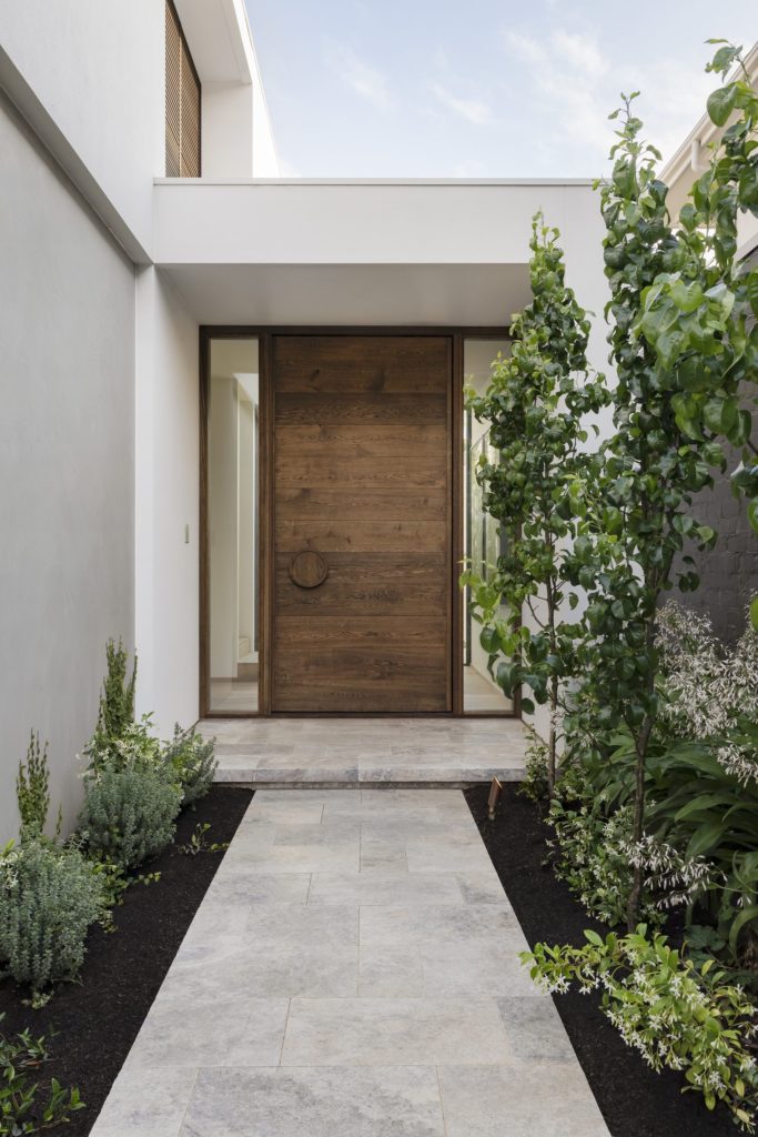 Porte d’entrée en bois sur mesure dans une entrée contemporaine