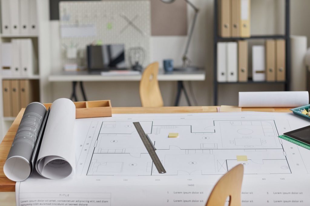 Plans d'architecte déroulés sur une table à dessin
