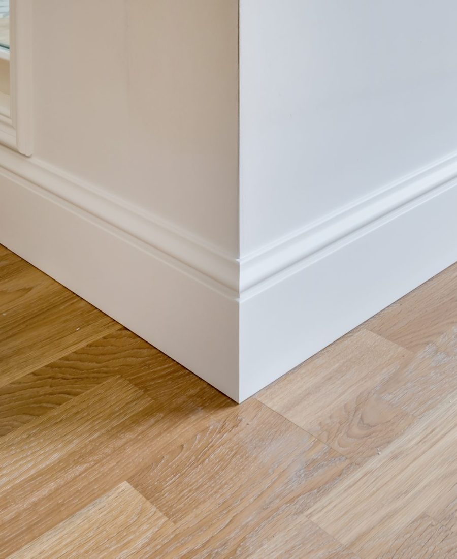 Détail d'un parquet en chêne et d'une plinthe moulurée blanche