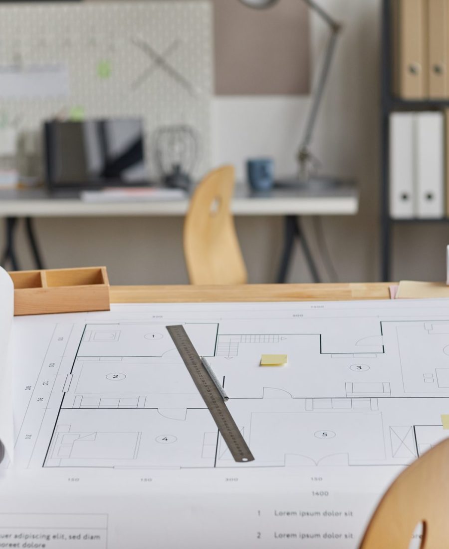 Plans d'architecte déroulés sur une table à dessin